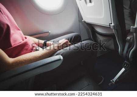 Man resting during flight. Legroom between seats in commercial airplane.  Royalty-Free Stock Photo #2254324631