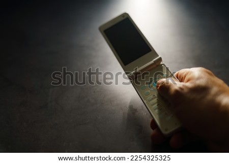Old used cell phone on dark background