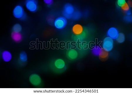 Colorful bokeh background. Abstract blurred background of city lights. Warm light with a beautiful round bokeh pattern. Orange light at night. Street lamp obscures the lights in the city at night.