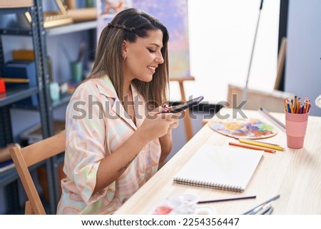Young hispanic woman artist smiling confident make photo to draw at art studio