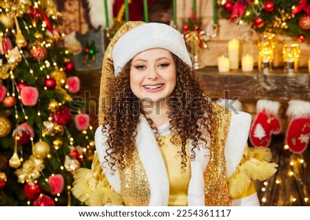 elf and christmas. Cheerful elf joyfully posing against the background of candles and a fireplace