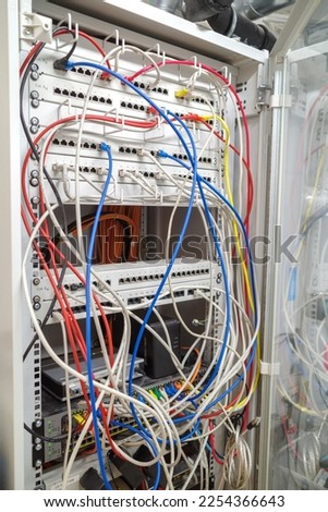 in the server rack many different colored network cables are connected to the network switches