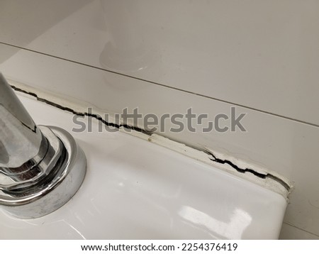 toilet in bathroom or restroom with crack in the wall or caulk Royalty-Free Stock Photo #2254376419