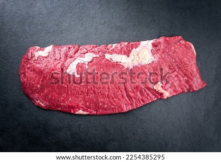 Raw wagyu bavette beef steak offered as top view on rustic black board with copy space Royalty-Free Stock Photo #2254385295