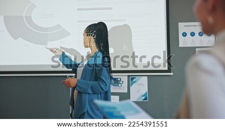 Meeting, presentation and business black woman with data analytics, profit review or growth strategy workshop. Marketing stats, sales charts and speaker in seminar on projector, training an audience Royalty-Free Stock Photo #2254391551