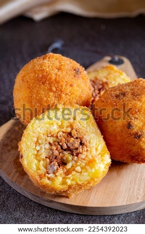 Fried stuffed Sicilian arancini with breadcrumbs crust Royalty-Free Stock Photo #2254392023