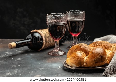 Shabbat Shalom challah bread, shabbat wine on a dark background, place for text, top view, Royalty-Free Stock Photo #2254400581