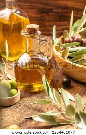 olives and oil. extra virgin olive oil jars on a wooden background. vertical image. place for text.