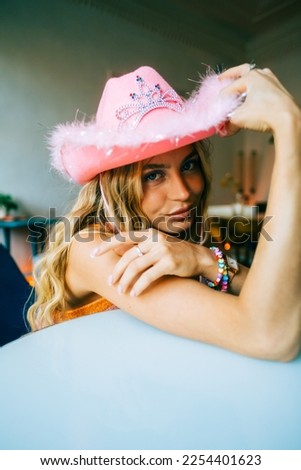 Portrait of attractive caucasian woman fashion model with blonde hair in pink cowboys hat , posing 