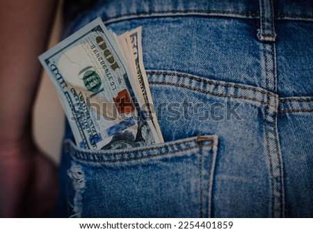 Money in my jeans pocket, 100 dollars in the back pocket of blue jeans. Wealth and prosperity concept. Copy space