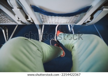 Personal perspective on legroom between seats in airplane. Man resting during flight. 
 Royalty-Free Stock Photo #2254422367