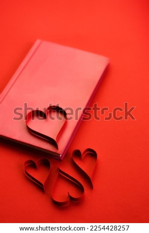 red book with hearts. Red background and texture. Valentine's Day. Postcard with a declaration of love. Valentine postcard.
