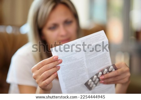 Woman reads medical instruction at home. Female with illness holds pills and prescription. Health, immune system support, disease concept. Royalty-Free Stock Photo #2254444945