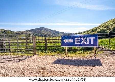 Exit sign on wooden fence of a farm and camping site