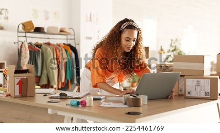 Logistics, laptop and fashion manager of retail or boutique shop checking clothing stock in boxes on a checklist. Small business, entrepreneur and young woman working with clothes inventory in store Royalty-Free Stock Photo #2254461769