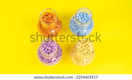 Colorful assorted pharmaceutical medicine pills, tablets and capsules and bottle on yellow background. Capsules Vitamin And Dietary Supplements