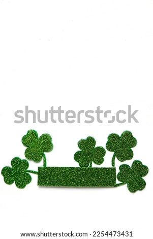 Happy St. Patrick's Day banner.Holiday background.St Patricks Day frame against a white background. Flat lay shamrocks.Copy space.Patrik's day banner Royalty-Free Stock Photo #2254473431