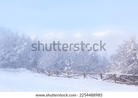 Peaks of Pirin mountains covered with snow in winter foggy day. Bansko, Bulgaria ski resort panorama with pine trees and wooden fence