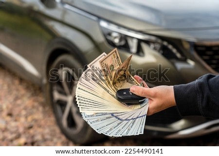 A Person with money and car key standing front car. Insurance, loan concept. Deal of buy or rent new car