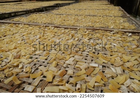 closeup picture of raw skin chips drying under the sun on bamboo tray 