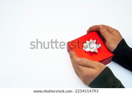 A pair of hands holding gift box on a white isolated background