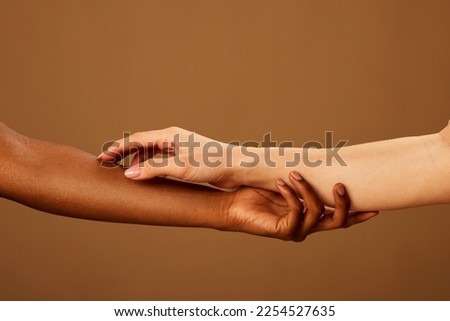 Cropped picture of a multicultural girls touching each other hands.