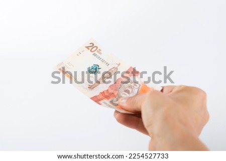a person hands over a twenty thousand colombian peso bill Royalty-Free Stock Photo #2254527733