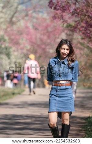 Woman with cherry blossoms or sakura flower blooming in the park
