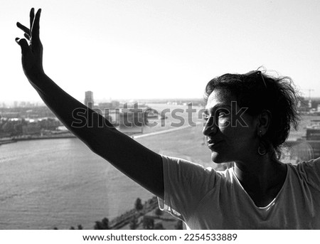 Woman looking at river in city against clear sky
