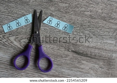 Scissor cut paper with employee icon. Mass layoffs, downsizing concept. Royalty-Free Stock Photo #2254565209