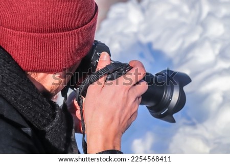 A stock photographer with a modern photo camera photographs nature for stocks