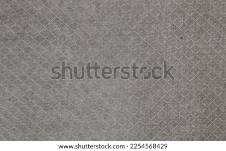 gray fabric background with a metal mesh in the foreground as a backdrop