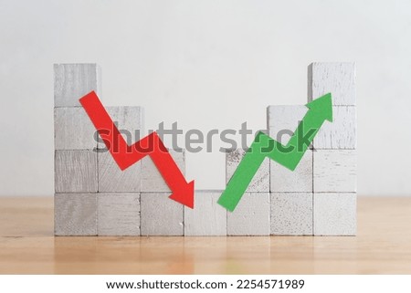 Wood bar chart and arrow red green graph chart volatility up and down on wooden table white wall background. Business, financial and investment concept. Risk, fluctuation in stock market and crypto