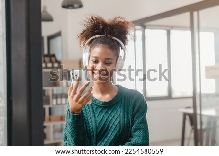 Pretty young african american student woman listen to music with headphones