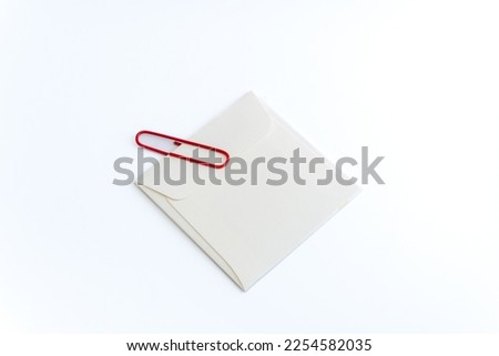 White envelope and Red Clip on white background with Clipping Path. Announcement, bulletin, newsletter, important note concept.