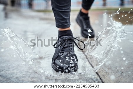 Shoes of person running in the rain, feet splash water in puddle and outdoor cardio in Seattle road. Runner training for marathon, step on wet ground and legs moving fast for fitness exercise Royalty-Free Stock Photo #2254585433