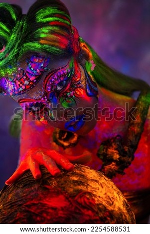 Ultraviolet. Photo shoot with neon colors. Neon makeup. Fluorescent body painting. A native from space. Galactic makeup.