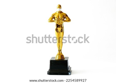 Hollywood Golden Oscar Academy award statue in mask on white background. Success and victory concept.