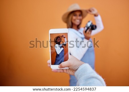 Friends taking picture on a phone of woman isolated on wall background on social media or digital memory. Hand holding smartphone screen for happy profile of gen z, influencer person in summer mockup