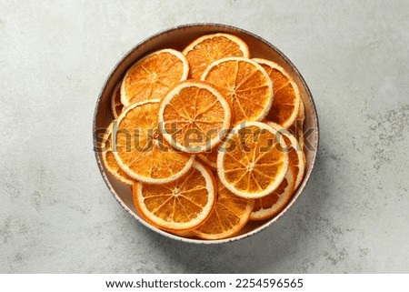 Bowl of dry orange slices on light table, top view Royalty-Free Stock Photo #2254596565
