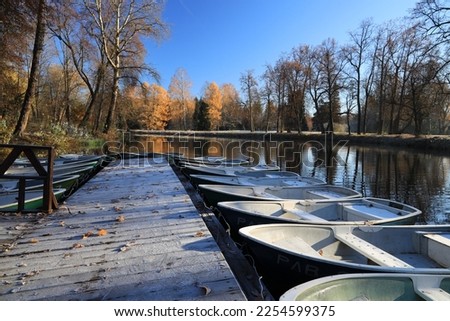 One row of boats near the pier on an autumn sunny morning