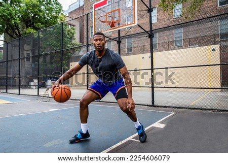 Athletic african american basketball player training on a court in New York - Sportive man playing basket outdoors Royalty-Free Stock Photo #2254606079