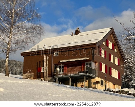 Old traditional swiss rural architecture and alpine livestock farms in the winter ambience over the Lake Walen or Lake Walenstadt (Walensee) and in the Swiss Alps, Amden - Switzerland (Schweiz)