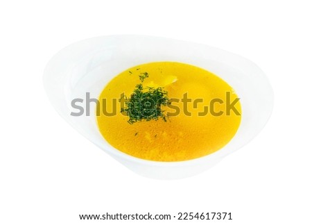 Golden broth with herbs in a white bowl. Traditional appetizing dish. Top view. Close-up. Isolated on a white background.
