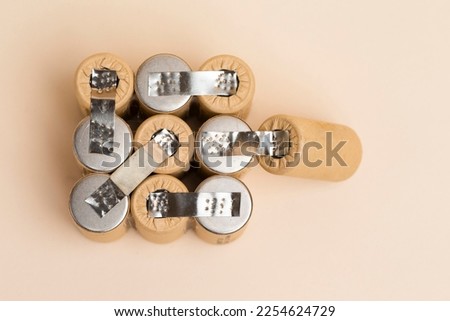 Upper View of Bundle of Soldered Ni-Mh Rechargeable Batteries  Placed Together Over Beige.Horizontal Composition Royalty-Free Stock Photo #2254624729