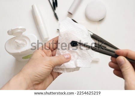 Cleaning makeup brushes with special disinfecting cloth. Hand holds the tool and wipes it. Royalty-Free Stock Photo #2254625219