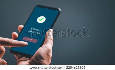A businessman hand holds a smartphone on the screen with the message money sent transfer Concept. business, banking, financial online transactions with mobile devices. Copy space, Blurred background Royalty-Free Stock Photo #2254625805