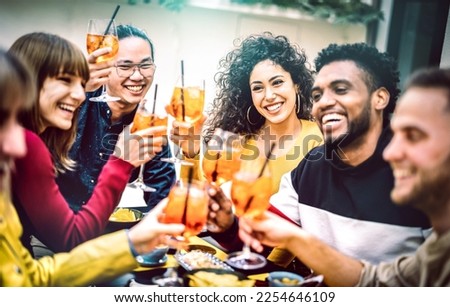 Trendy friends toasting spritz cocktail at bar restaurant - Life style concept with young people having fun together sharing drinks on happy hour at garden party - Vivid contrast filtered color tones Royalty-Free Stock Photo #2254646109