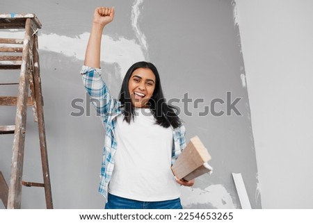 Young Indian woman raises fist proud of DIY construction progress carry timber Royalty-Free Stock Photo #2254653265