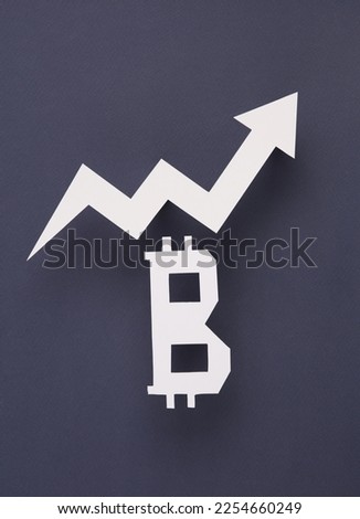 Btcoin symbol cut out of paper with a growth arrow on a gray background. Finance concept